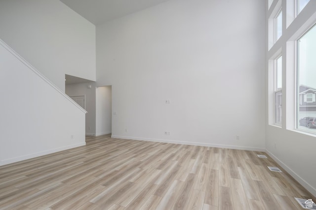 1847 E Badger Ave N Unit B253, Eagle Mountain, UT 84005 - empty room with a towering ceiling, stairs, light wood-type flooring, and baseboards