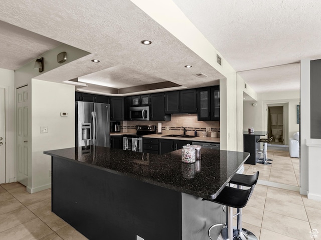 105 S 1100 E Unit 508, Salt Lake City, UT 84102 - kitchen with stainless steel appliances, dark cabinetry, a textured ceiling, a sink, and light tile patterned flooring