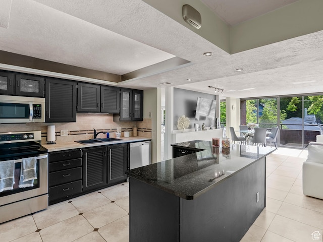 105 S 1100 E Unit 508, Salt Lake City, UT 84102 - kitchen featuring stainless steel appliances, a sink, dark cabinets, light tile patterned floors, and a textured ceiling