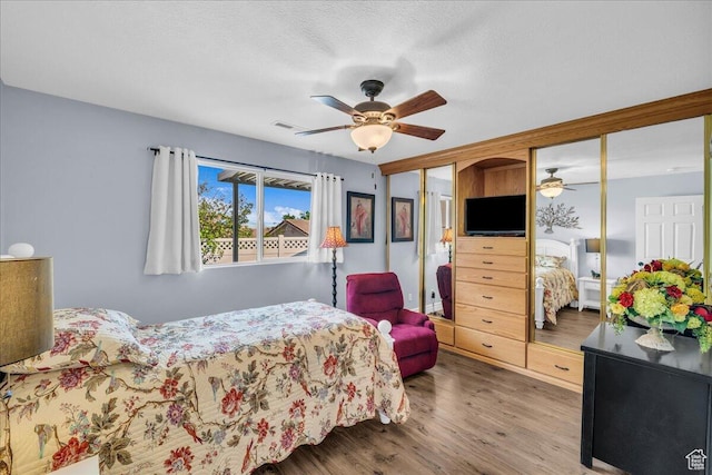 1050 W Red Hills Pkwy Unit 100A, Washington, UT 84780 - bedroom featuring multiple closets, wood finished floors, and a ceiling fan