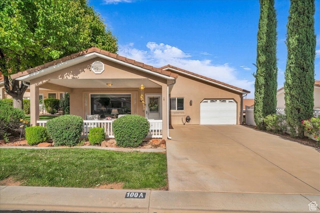 1050 W Red Hills Pkwy Unit 100A, Washington, UT 84780 - view of front of house with a porch, a garage, concrete driveway, stucco siding, and a front lawn