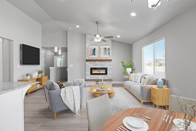 4972 N Sage Park Dr, Eagle Mountain, UT 84005 - living room featuring light wood-style flooring, lofted ceiling, a stone fireplace, a ceiling fan, and recessed lighting