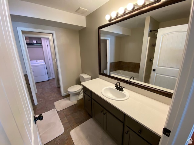 85 River Pointe Dr, Logan, UT 84321 - bathroom with washer / clothes dryer, a garden tub, toilet, vanity, and tile patterned flooring