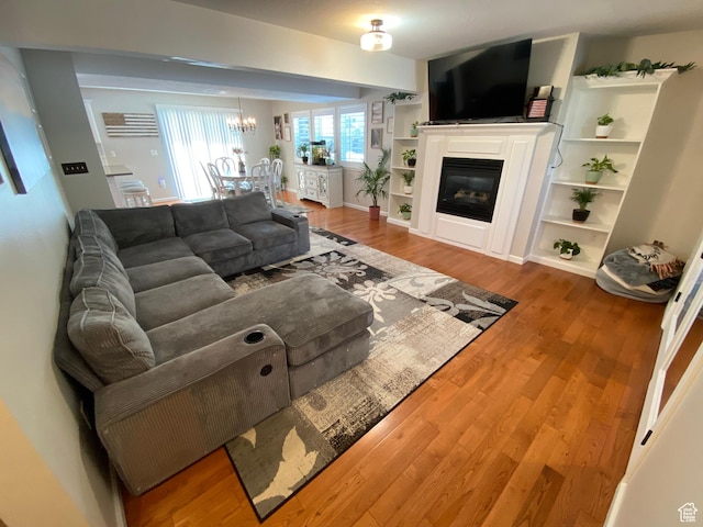 85 River Pointe Dr, Logan, UT 84321 - living room with wood finished floors, a chandelier, and a glass covered fireplace