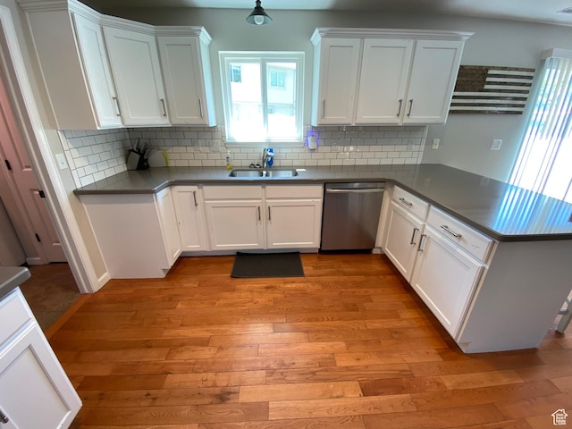 85 River Pointe Dr, Logan, UT 84321 - kitchen featuring stainless steel dishwasher, a sink, a peninsula, light wood finished floors, and white cabinetry