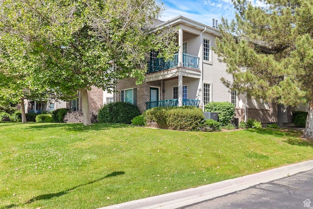 4910 N University Ave Unit 52, Provo, UT 84604 - view of front of property with a balcony, stucco siding, brick siding, and a front lawn