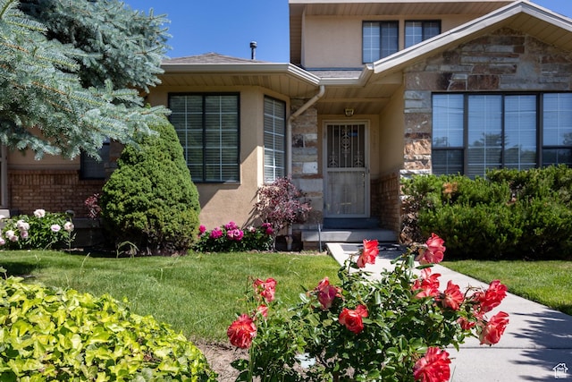 1155 E Murray Holladay Rd, Millcreek, UT 84117 - view of exterior entry featuring stone siding, stucco siding, and a lawn