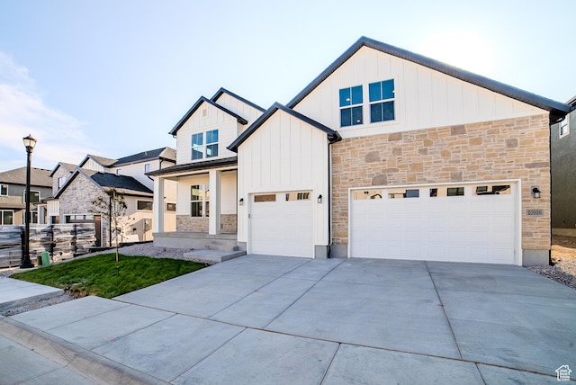 10926 S Little Sahara Dr Unit 1002, South Jordan, UT 84009 - view of front facade featuring stone siding, board and batten siding, concrete driveway, and an attached garage