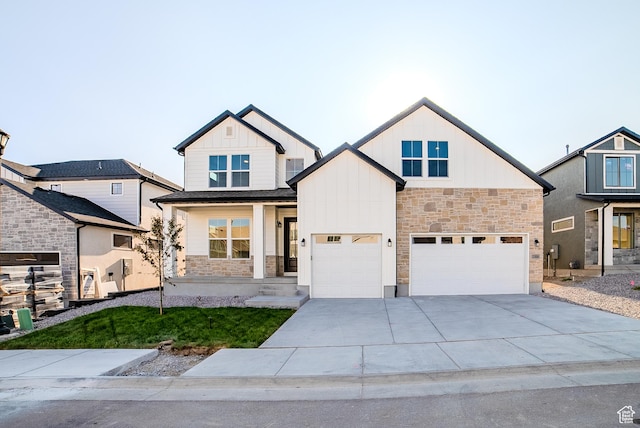 10926 S Little Sahara Dr Unit 1002, South Jordan, UT 84009 - view of front of property with stone siding, board and batten siding, driveway, an attached garage, and a porch