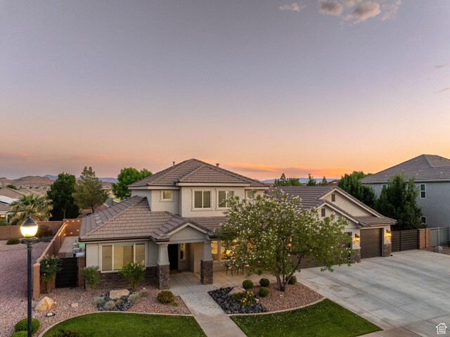 2914 E 1880 S, St George, UT 84790 - view of front facade with a tiled roof, stucco siding, concrete driveway, a garage, and stone siding