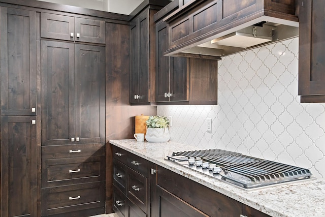 2914 E 1880 S, St George, UT 84790 - kitchen with stainless steel gas stovetop, dark brown cabinetry, decorative backsplash, light stone countertops, and wall chimney exhaust hood
