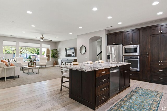 2914 E 1880 S, St George, UT 84790 - kitchen featuring stainless steel appliances, open floor plan, arched walkways, recessed lighting, and a kitchen bar