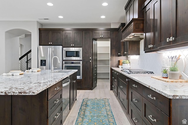 2914 E 1880 S, St George, UT 84790 - kitchen featuring stainless steel appliances, dark brown cabinetry, arched walkways, decorative backsplash, and recessed lighting