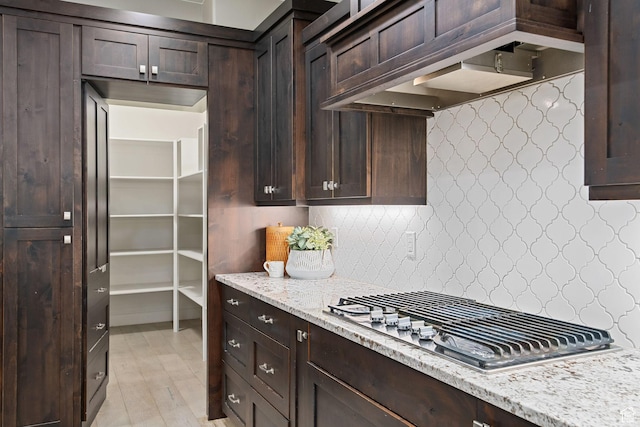 2914 E 1880 S, St George, UT 84790 - kitchen featuring stainless steel gas cooktop, dark brown cabinets, decorative backsplash, light stone countertops, and light wood finished floors