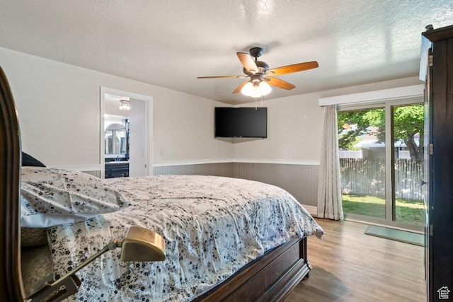 2045 W 5025 S, Roy, UT 84067 - bedroom featuring access to exterior, wainscoting, wood finished floors, a ceiling fan, and a textured ceiling