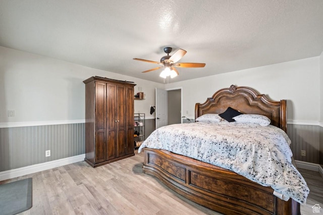2045 W 5025 S, Roy, UT 84067 - bedroom with light wood finished floors, a wainscoted wall, and a ceiling fan