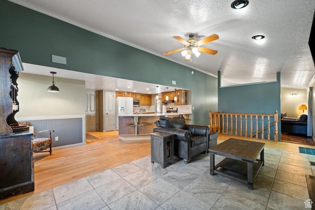 2045 W 5025 S, Roy, UT 84067 - living area with ornamental molding, ceiling fan, a textured ceiling, light wood-type flooring, and vaulted ceiling