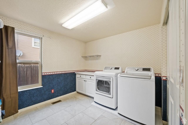 2045 W 5025 S, Roy, UT 84067 - laundry area featuring cabinet space, wallpapered walls, independent washer and dryer, a textured ceiling, and light tile patterned flooring