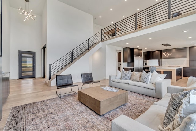 13393 S Sky Ranch Rd, Herriman, UT 84096 - living area with a towering ceiling, stairway, light wood-style flooring, and recessed lighting