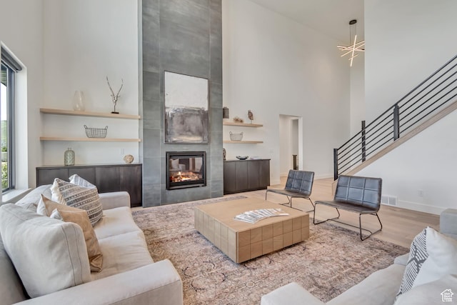 13393 S Sky Ranch Rd, Herriman, UT 84096 - living room with a towering ceiling, plenty of natural light, stairway, wood finished floors, and a tile fireplace