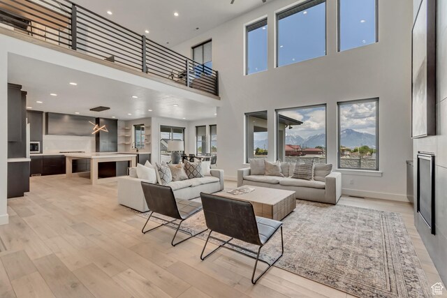 13393 S Sky Ranch Rd, Herriman, UT 84096 - living room featuring a high ceiling, light wood-style flooring, baseboards, and recessed lighting