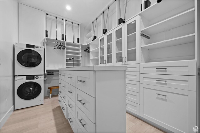 4771 W Juniper Bend Cir, Herriman, UT 84096 - walk in closet featuring stacked washer and clothes dryer and light wood-type flooring