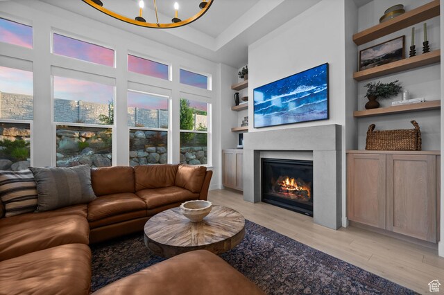 4771 W Juniper Bend Cir, Herriman, UT 84096 - living area featuring light wood-style floors, a glass covered fireplace, and built in features