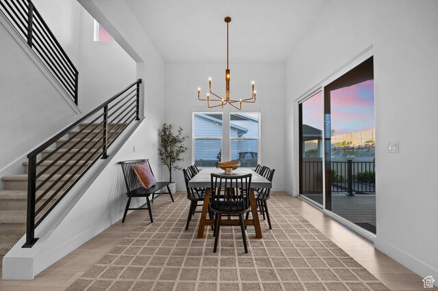4771 W Juniper Bend Cir, Herriman, UT 84096 - dining area featuring a chandelier, stairway, light wood-style flooring, a towering ceiling, and baseboards