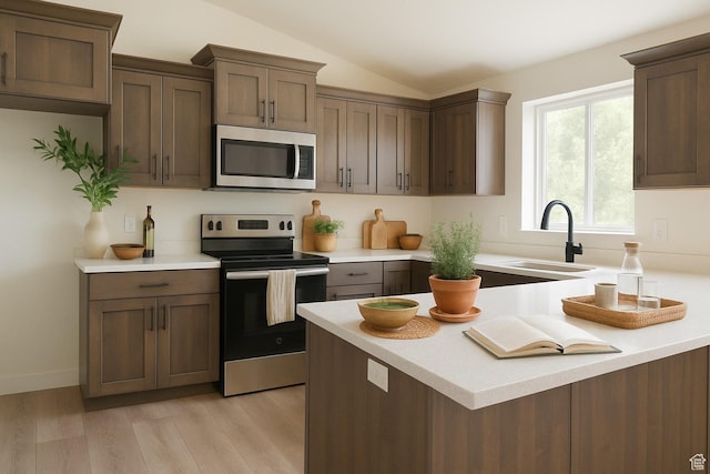 3167 W 5700 S, Roy, UT 84067 - kitchen featuring appliances with stainless steel finishes, a sink, light countertops, light wood-style floors, and vaulted ceiling