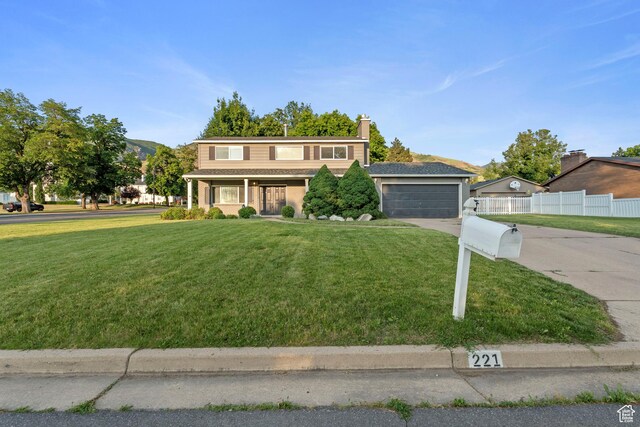 221 S 200 E, Centerville, UT 84014 - traditional home featuring concrete driveway, an attached garage, covered porch, and a chimney