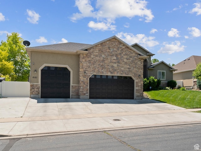 6121 W Indian Oak Dr S, West Jordan, UT 84081 - view of front facade with an attached garage, driveway, stone siding, stucco siding, and a front yard