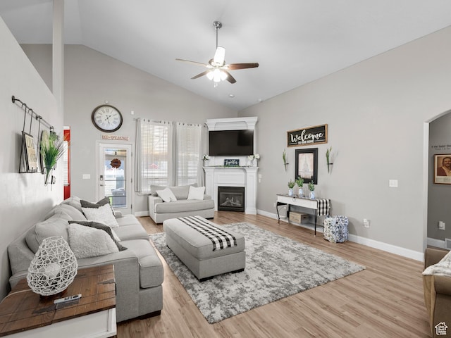 6121 W Indian Oak Dr S, West Jordan, UT 84081 - living area with a ceiling fan, a glass covered fireplace, wood finished floors, baseboards, and high vaulted ceiling
