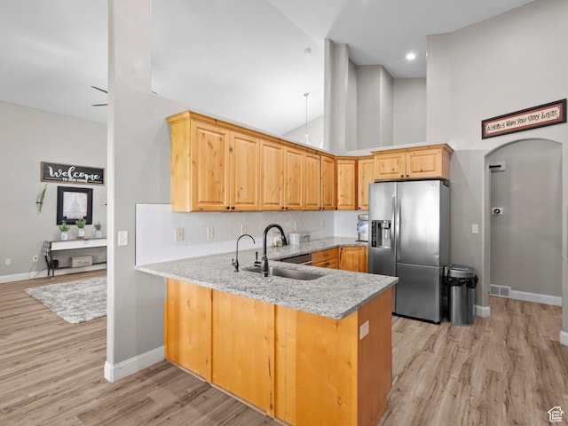 6121 W Indian Oak Dr S, West Jordan, UT 84081 - kitchen with stainless steel fridge, a sink, a peninsula, baseboards, and light wood-style floors