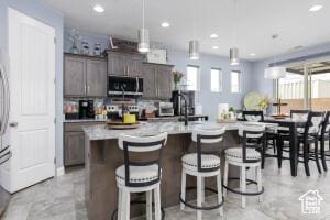 3454 W 150th St N, Hurricane, UT 84737 - kitchen with stainless steel microwave, light countertops, recessed lighting, a breakfast bar area, and a center island with sink