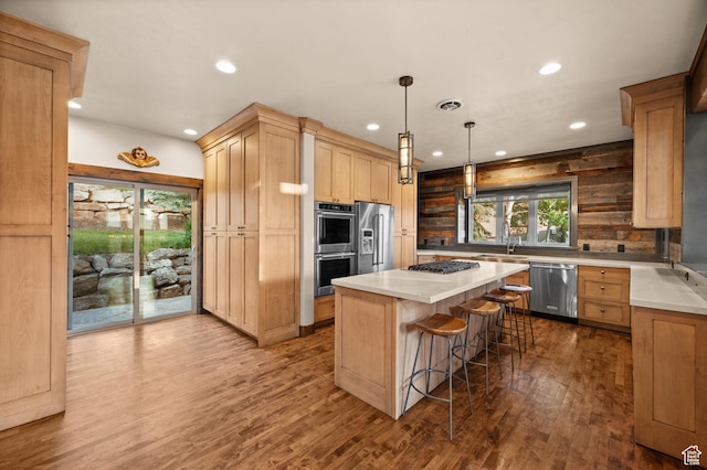 8932 Flint Way, Park City, UT 84098 - kitchen with appliances with stainless steel finishes, recessed lighting, light brown cabinets, a kitchen bar, and dark wood-style floors