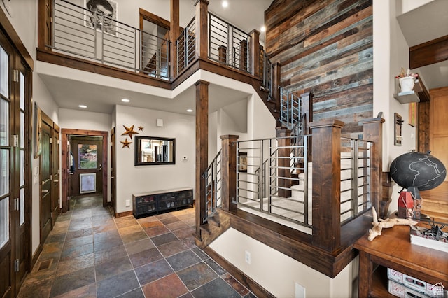 8932 Flint Way, Park City, UT 84098 - entryway with a towering ceiling, stairway, stone tile flooring, wood walls, and baseboards