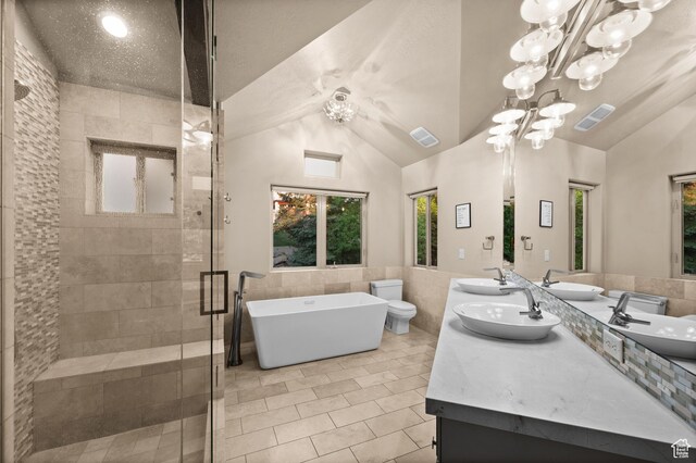 8932 Flint Way, Park City, UT 84098 - bathroom featuring tile walls, double vanity, a freestanding bath, a stall shower, and lofted ceiling