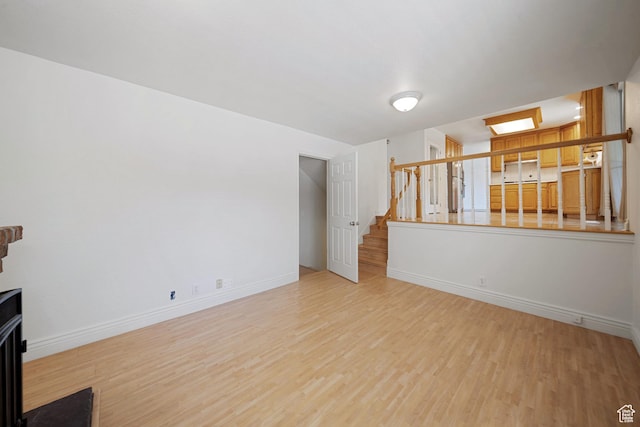 1591 E Waters Ln, Sandy, UT 84093 - unfurnished living room featuring light wood-style flooring, stairway, and baseboards