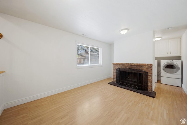 1591 E Waters Ln, Sandy, UT 84093 - unfurnished living room with light wood finished floors, baseboards, a brick fireplace, and separate washer and dryer
