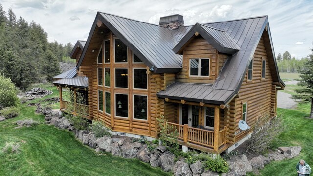 2665 Government Dam Rd, Soda Springs, ID 83276 - back of house featuring log siding, a standing seam roof, metal roof, a chimney, and a yard