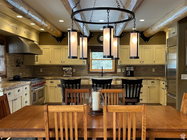 2665 Government Dam Rd, Soda Springs, ID 83276 - kitchen with premium appliances, beamed ceiling, backsplash, wall chimney exhaust hood, and a center island