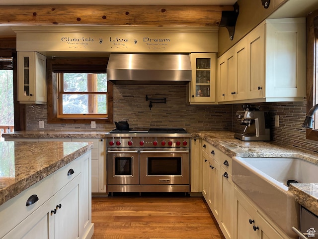2665 Government Dam Rd, Soda Springs, ID 83276 - kitchen featuring double oven range, wall chimney range hood, a sink, wood finished floors, and tasteful backsplash