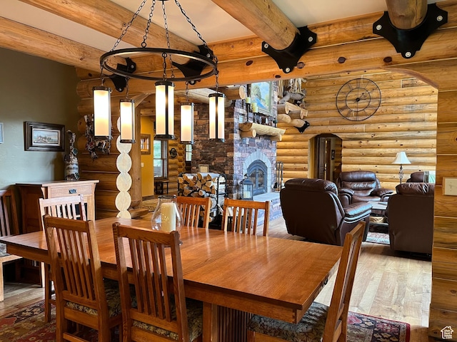2665 Government Dam Rd, Soda Springs, ID 83276 - dining room featuring log walls, hardwood / wood-style floors, beamed ceiling, and a fireplace