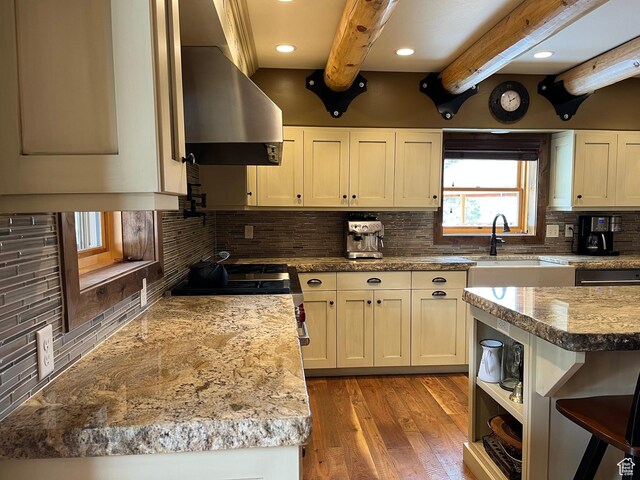 2665 Government Dam Rd, Soda Springs, ID 83276 - kitchen featuring wall chimney range hood, beam ceiling, decorative backsplash, stainless steel range, and light wood-style floors