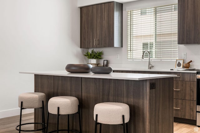 2353 W Miles Ln Unit D14, West Haven, UT 84401 - kitchen featuring a breakfast bar, light countertops, dark brown cabinets, and modern cabinets