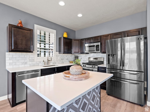 9558 S Lea Heather Way, West Jordan, UT 84081 - kitchen with appliances with stainless steel finishes, a sink, dark brown cabinetry, light countertops, and recessed lighting