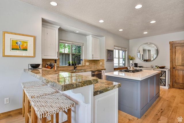 7841 Engen Loop, Park City, UT 84098 - kitchen with a center island, a sink, a textured ceiling, white cabinetry, and decorative backsplash