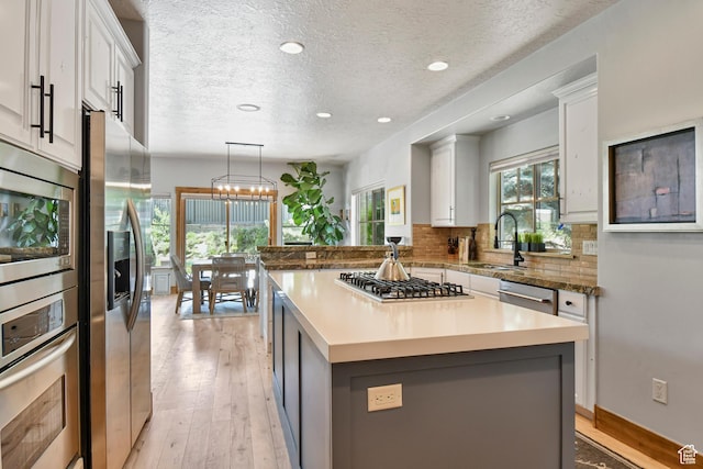 7841 Engen Loop, Park City, UT 84098 - kitchen featuring appliances with stainless steel finishes, a sink, light wood-type flooring, a textured ceiling, and recessed lighting