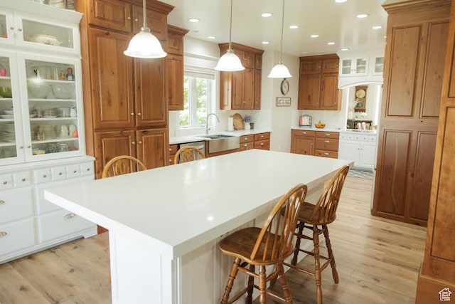 1380 N 300 W, Blanding, UT 84511 - kitchen featuring light wood-style flooring, a breakfast bar, brown cabinetry, glass insert cabinets, and recessed lighting