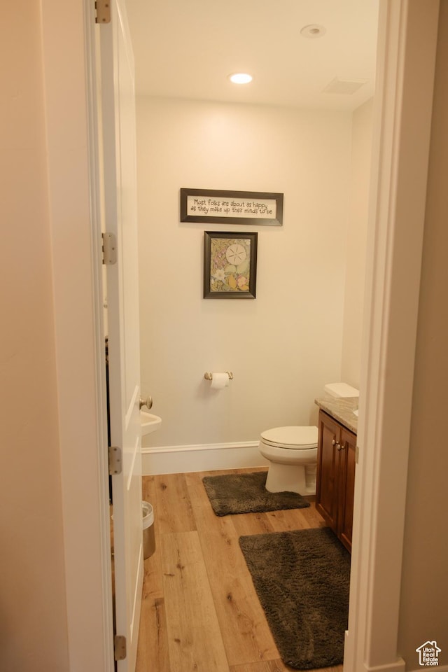 1380 N 300 W, Blanding, UT 84511 - bathroom with wood finished floors, toilet, vanity, baseboards, and recessed lighting